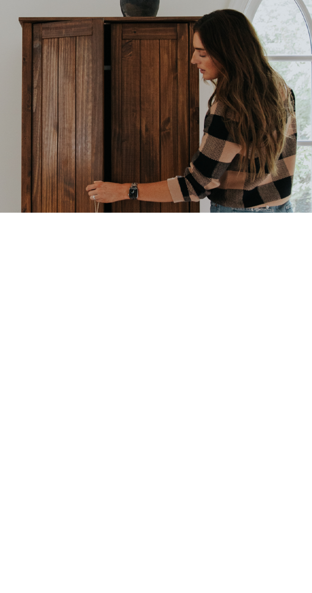 Person opening a stained wooden cabinet