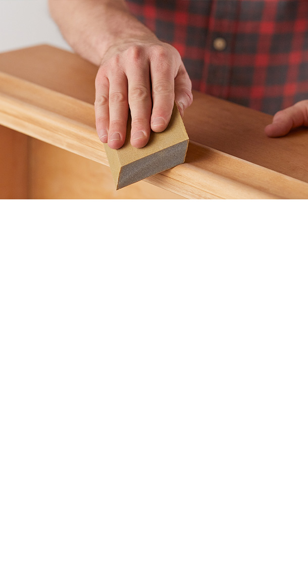 A man in a plaid shirt applies Wipe-On Polyurethane, after Minwax Antique Refinisher, to a dresser.